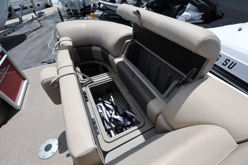 Slide: The Image of 2023 SUNTRACKER PB 22DLX boat with open storage compartment and beige seating. - 26