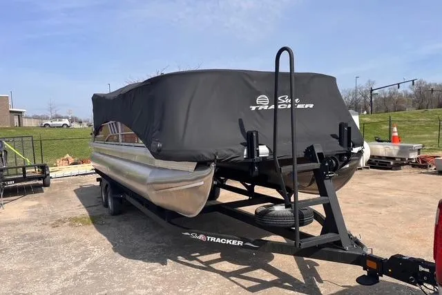 Slide: The Image of 2023 SUNTRACKER PB 22DLX pontoon boat on trailer with cover in outdoor setting. - 27