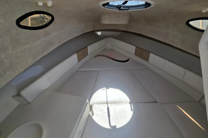 Slide: The Image of Interior cabin of 2003 Seaswirl Striper 2301 Walkaround OB boat, featuring cushioned seating. - 22