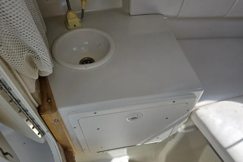 Slide: The Image of 2003 Seaswirl Striper 2301 Walkaround OB cabin sink and storage area. - 24