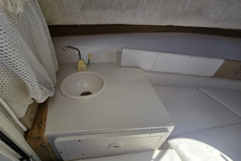 Slide: The Image of 2003 Seaswirl Striper 2301 Walkaround OB cabin sink and seating area. - 26
