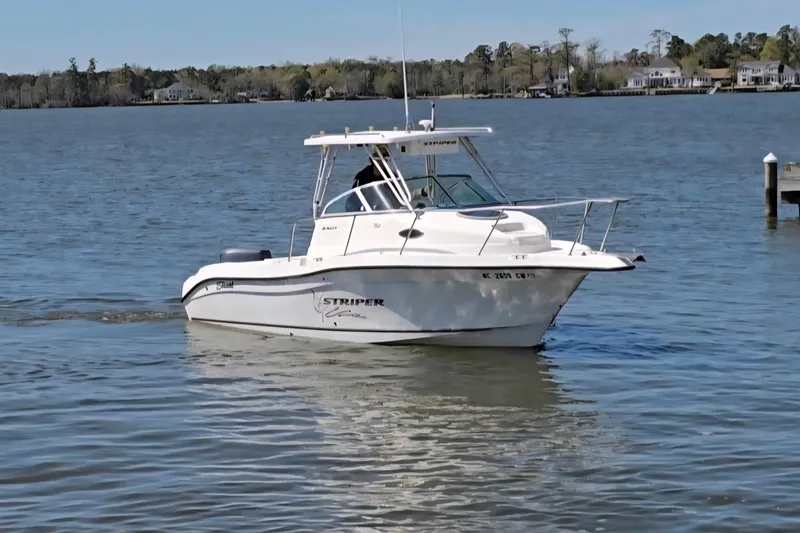 Slide: The Image of 2003 Seaswirl Striper 2301 Walkaround OB boat on calm water near shoreline. - 32