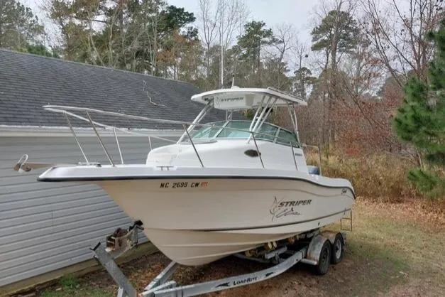 Slide: The Image of 2003 Seaswirl Striper 2301 Walkaround OB boat on trailer near house and trees. - 33
