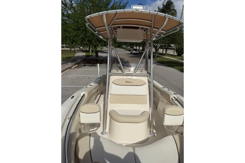 Slide: The Image of 2017 Pioneer 202 Islander boat with beige seating and T-top in a parking area. - 21