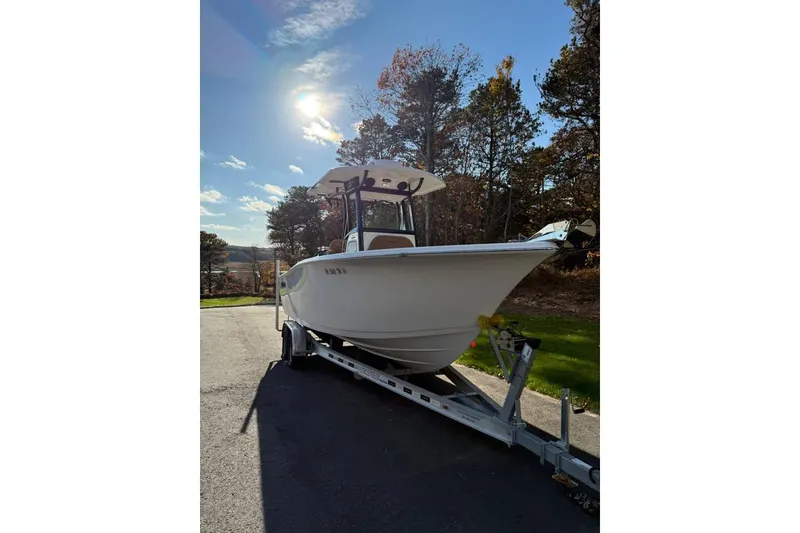 Slide: The Image of 2024 Sea Pro 242 Center Console boat on trailer, parked outdoors under sunny sky. - 3