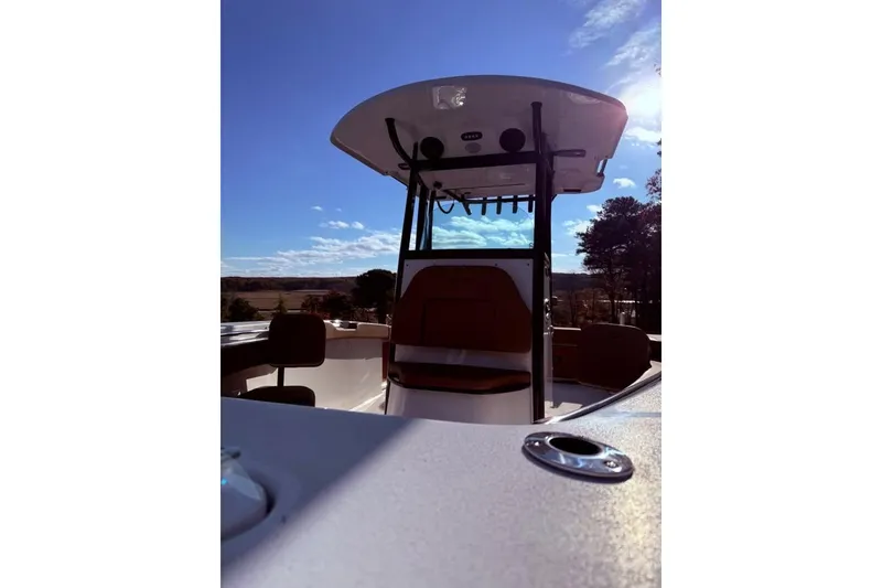 Slide: The Image of 2024 Sea Pro 242 Center Console boat under clear blue sky, showcasing helm and seating. - 5