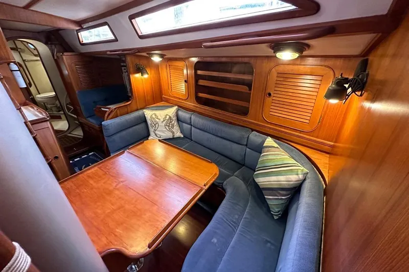 Slide: The Image of Cozy interior of 1989 Hylas 44 yacht with wooden table and blue seating. - 12