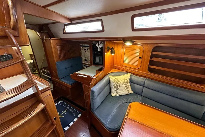 Slide: The Image of Cozy interior of 1989 Hylas 44 yacht with wooden furnishings and blue seating. - 14