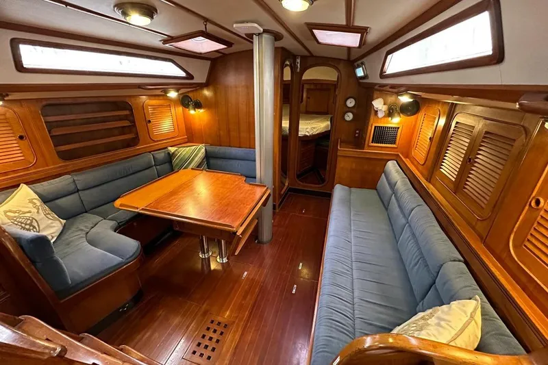 Slide: The Image of Luxurious interior of a 1989 Hylas 44 yacht with wooden finishes and blue seating. - 15