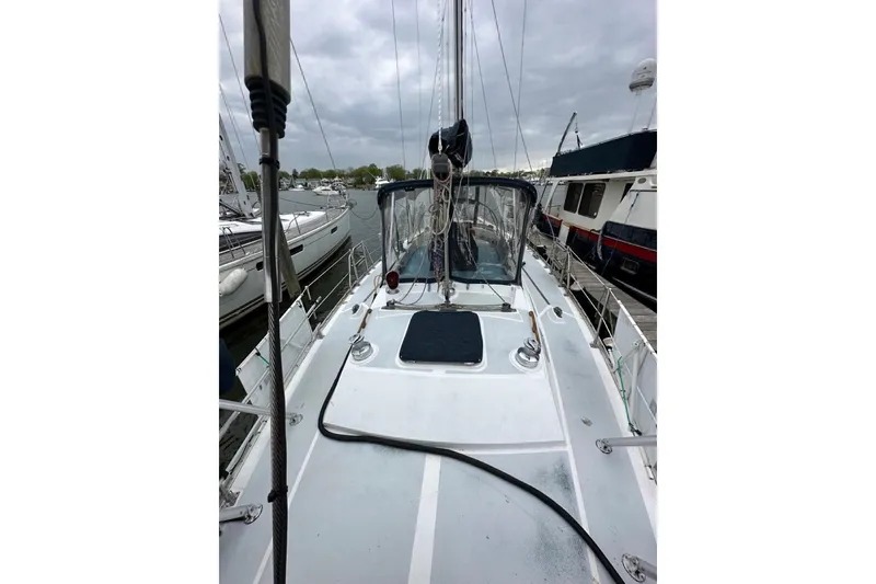 Slide: The Image of 1989 Hylas 44 sailboat docked, featuring deck and rigging under cloudy skies. - 40
