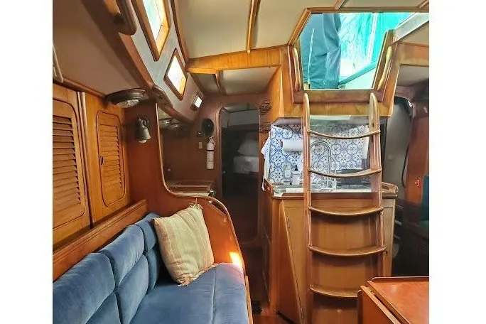 Slide: The Image of Interior of 1989 Hylas 44 yacht with wooden finish and blue seating. - 7