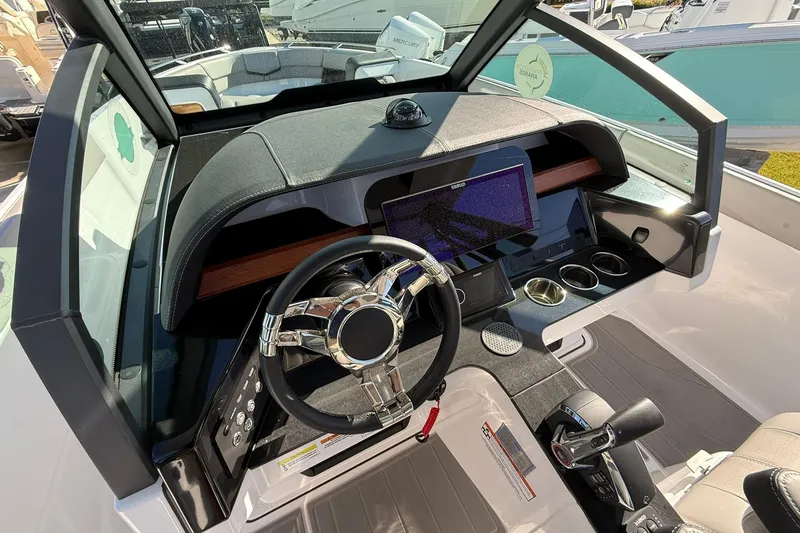 Slide: The Image of Cockpit of 2026 Monterey Elite 27 OB boat with modern steering and dashboard controls. - 8