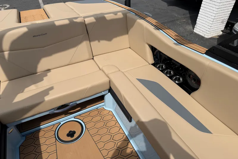 Slide: The Image of 2025 MasterCraft NXT22 boat interior with beige seating and stylish flooring design. - 10