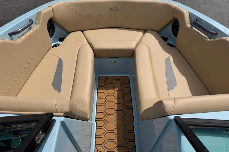Slide: The Image of 2025 MasterCraft NXT22 boat interior with beige seating and hexagonal floor design. - 13