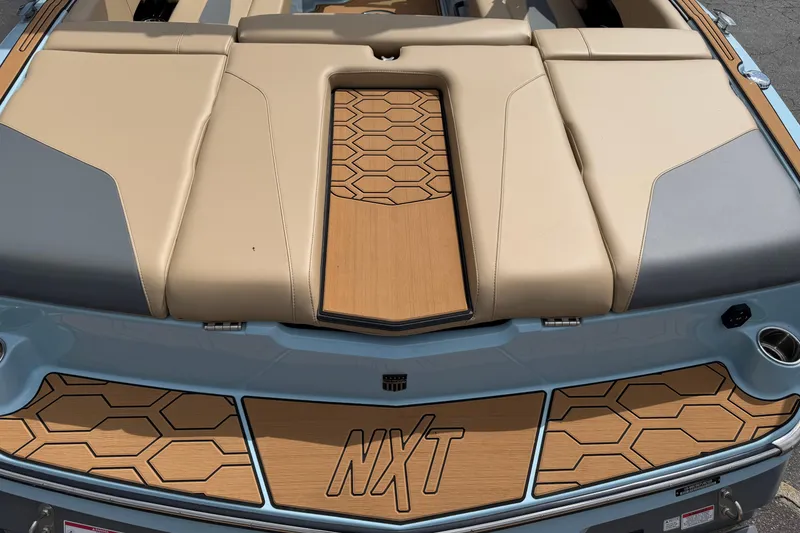 Slide: The Image of 2025 MasterCraft NXT22 boat with beige seating and hexagonal pattern design. - 6