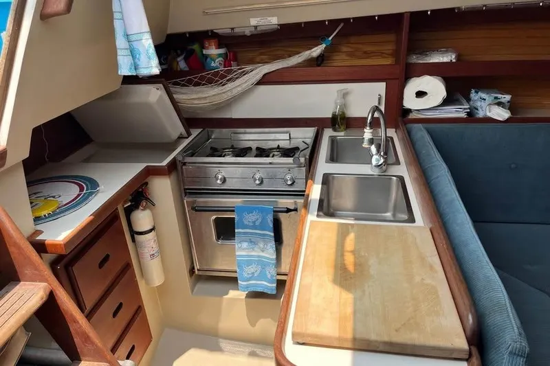 Slide: The Image of Compact kitchen area in a 1988 Catalina 30 MkII sailboat, featuring stove, sink, and storage. - 3