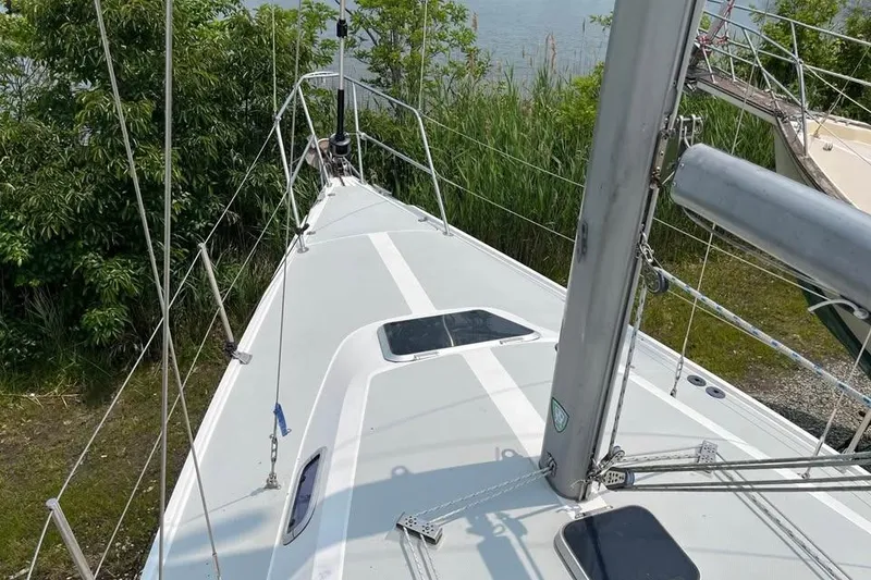 Slide: The Image of 1988 Catalina 30 MkII sailboat deck with lush greenery in the background. - 7