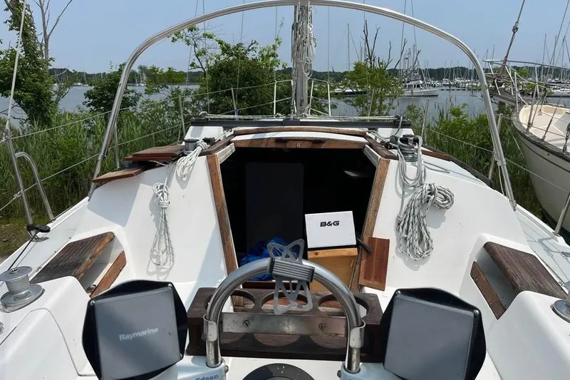 Slide: The Image of 1988 Catalina 30 MkII sailboat cockpit with navigation equipment and lush marina background. - 8