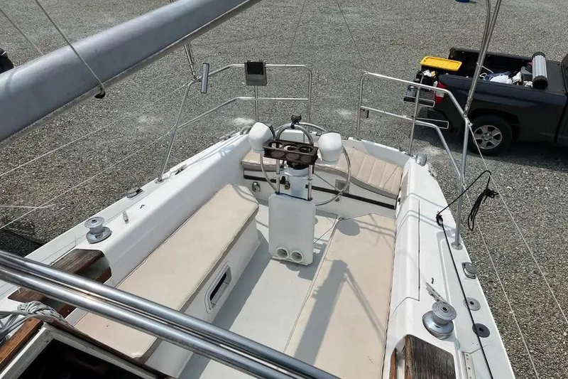 Slide: The Image of 1988 Catalina 30 MkII sailboat cockpit with steering wheel and seating, parked on gravel. - 9