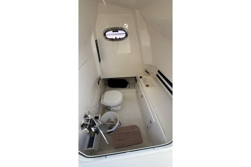 Slide: The Image of Interior of 2023 Boston Whaler 330 Outrage boat, featuring a compact marine toilet. - 13