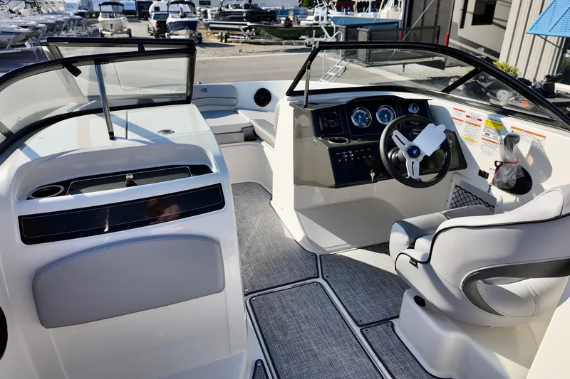 Slide: The Image of 2026 Bayliner VR6 Bowrider OB interior with modern dashboard and seating at marina. - 14