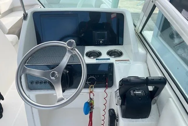 Slide: The Image of 2022 World Cat 230 SD boat dashboard with steering wheel and controls. - 4