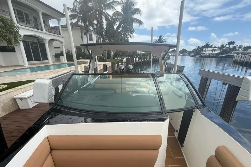 Slide: The Image of 2022 Aviara AV32 OB boat with tan seating, docked by waterfront homes. - 12