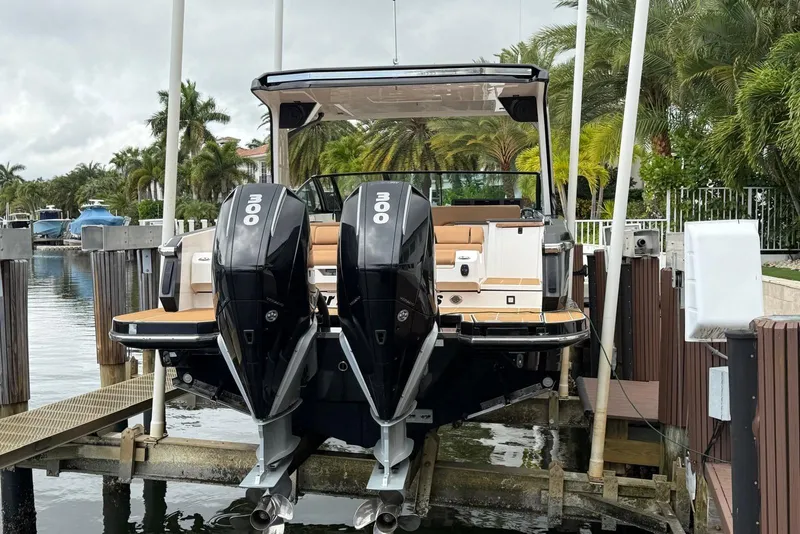 Slide: The Image of 2022 Aviara AV32 OB boat with dual Mercury engines docked near palm trees. - 17