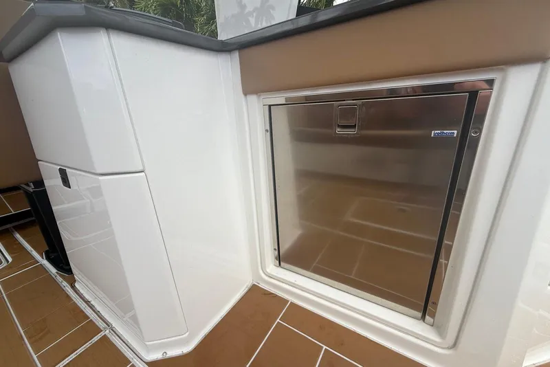 Slide: The Image of 2022 Aviara AV32 OB boat with dual 300 horsepower engines docked by palm trees. - 18