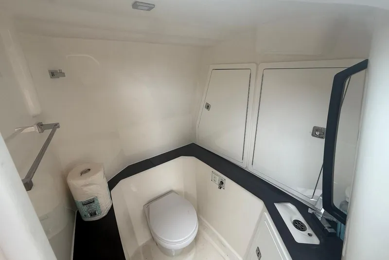 Slide: The Image of 2022 Aviara AV32 OB boat bathroom with toilet, sink, and storage cabinets. - 21