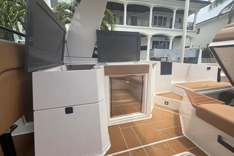 Slide: The Image of 2022 Aviara AV32 OB boat interior with sleek countertop and built-in refrigerator. - 9