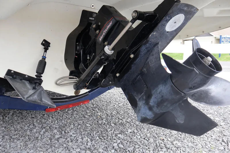 Slide: The Image of 2018 Larson LX 195 I/O boat's outboard motor and propeller on gravel surface. - 12