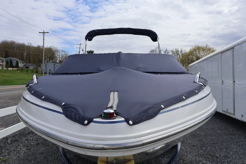 Slide: The Image of 2018 Larson LX 195 I/O boat with cover, parked outdoors on gravel. - 17