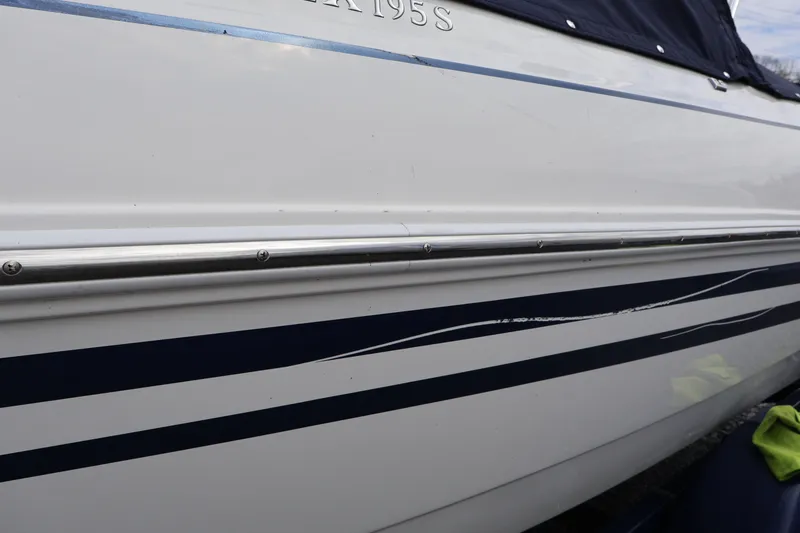 Slide: The Image of 2018 Larson LX 195 I/O boat side view with blue stripes and metal trim. - 21