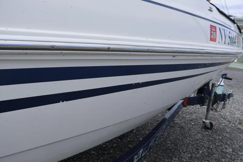 Slide: The Image of 2018 Larson LX 195 I/O boat on trailer, featuring blue stripes and registration details. - 25