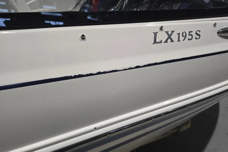 Slide: The Image of 2018 Larson LX 195 I/O boat on trailer, parked in residential area. - 8