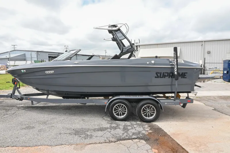 Slide: The Image of 2024 Supreme S220 boat on trailer, sleek gray design, parked outdoors. - 15