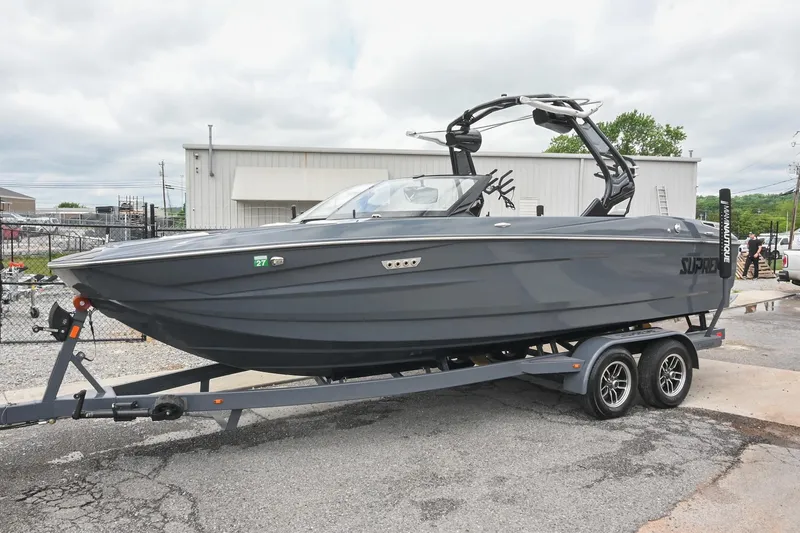 Slide: The Image of 2024 Supreme S220 boat on trailer, sleek design, parked outdoors. - 16