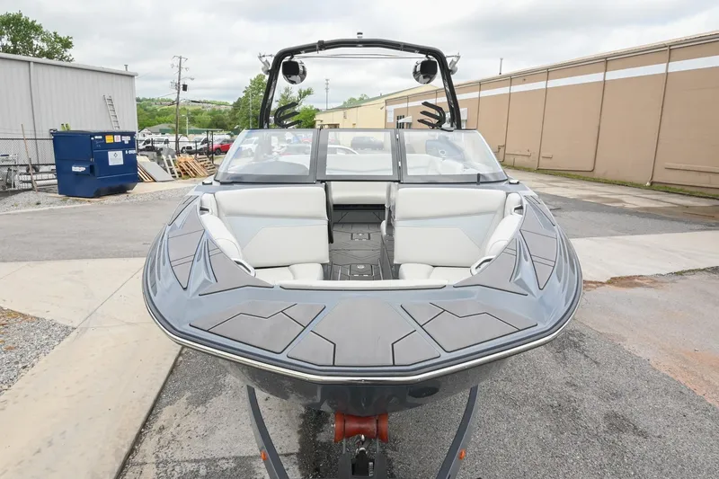 Slide: The Image of 2024 Supreme S220 boat with sleek design and spacious seating, parked outdoors. - 17
