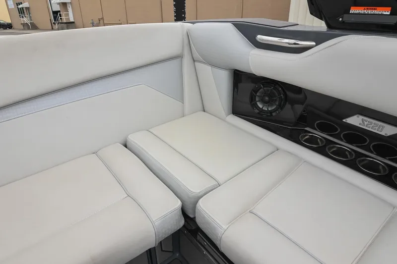 Slide: The Image of 2024 Supreme S220 boat interior with white seating, speaker, and cup holders. - 28