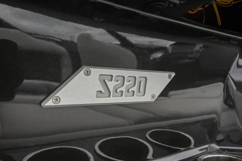 Slide: The Image of 2024 Supreme S220 model badge on sleek black surface. - 33