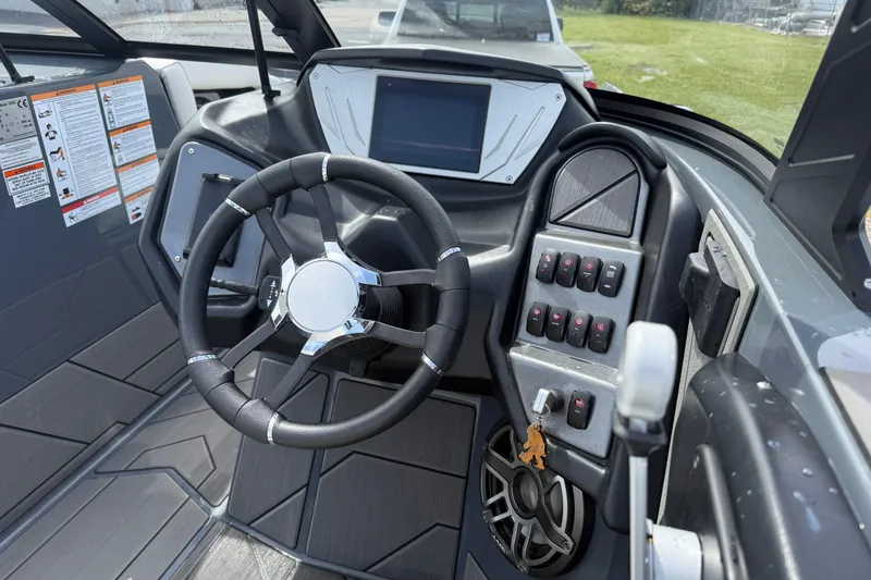 Slide: The Image of 2024 Supreme S220 boat dashboard with steering wheel and control panel. - 9