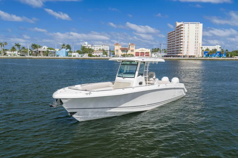 The Image of 2021 Boston Whaler 330 Outrage boat on calm water near urban shoreline. - 1