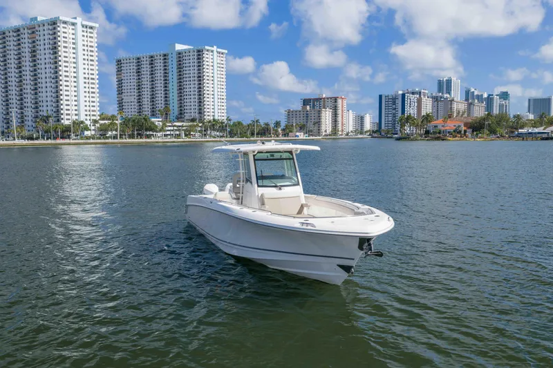 Slide: The Image of 2021 Boston Whaler 330 Outrage boat on water with city skyline background. - 12