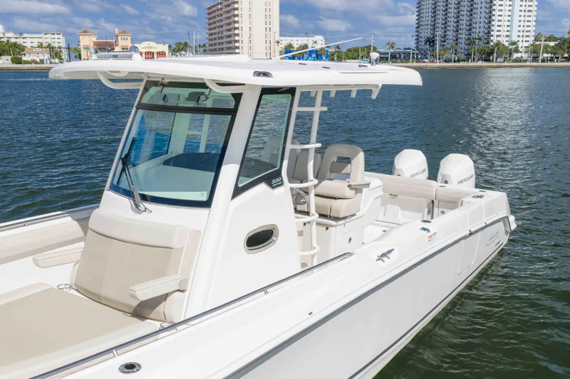 Slide: The Image of 2021 Boston Whaler 330 Outrage boat on water, cityscape background. - 16