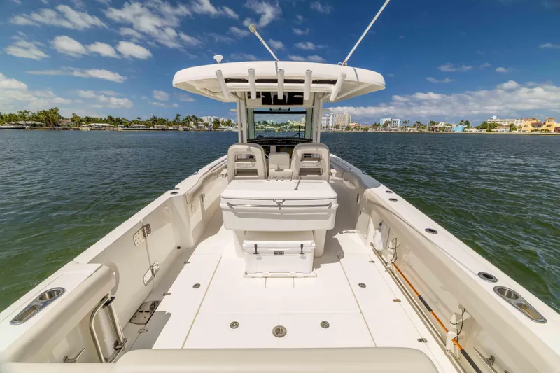 Slide: The Image of 2021 Boston Whaler 330 Outrage boat on calm water, clear sky, coastal view. - 21