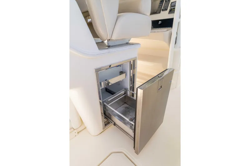 Slide: The Image of 2021 Boston Whaler 330 Outrage boat interior with open stainless steel storage compartment. - 22