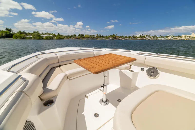 Slide: The Image of 2021 Boston Whaler 330 Outrage boat interior with seating and table on a sunny day. - 23