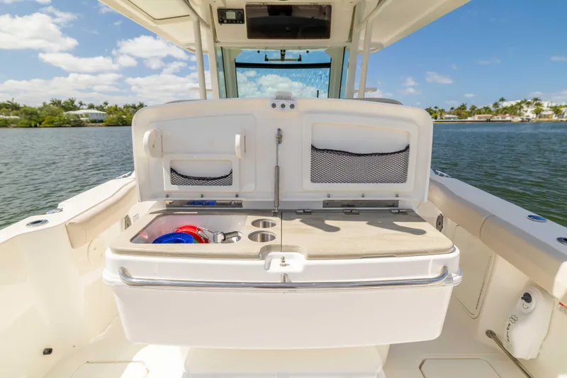 Slide: The Image of Boston Whaler 330 Outrage 2021 boat with open storage compartment on deck. - 25