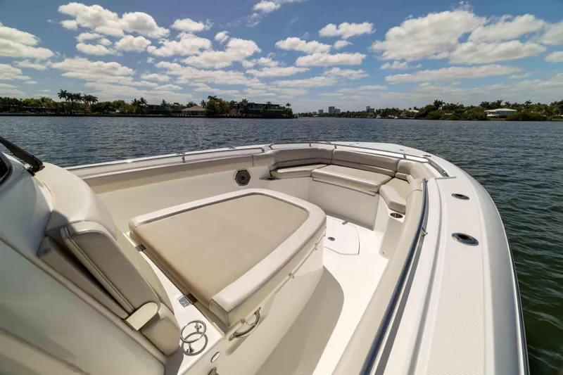 Slide: The Image of 2021 Boston Whaler 330 Outrage boat on calm water under a partly cloudy sky. - 26